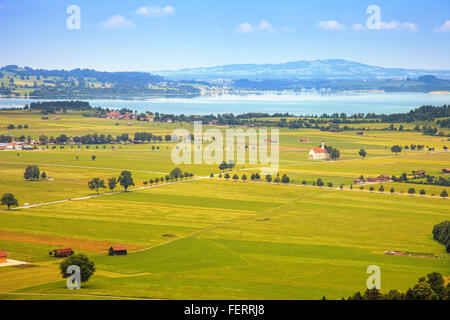 Bayern-Landschaft von Schloss Neuschwanstein. Schwangau-Dorf und Forggensee See im Hintergrund. Stockfoto