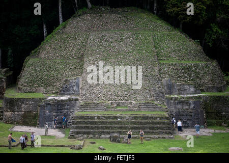 Touristen gehen durch eine pyramidenförmige Tempel in der Maya-Stadt von Caracol, Cayo, Belize Stockfoto