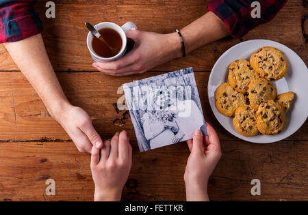 Mans und Womans Hände. Schwarz-weiß-Foto. Paar. Tee und Gebäck. Stockfoto