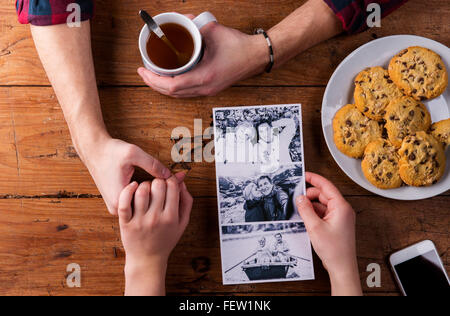 Mans und Womans Hände. Schwarz-weiß-Foto. Paar. Tee und Gebäck. Stockfoto