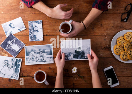 Mans und Womans Hände. Schwarz-weiß-Fotos. Paar. Tee, Kekse, Telefon. Stockfoto