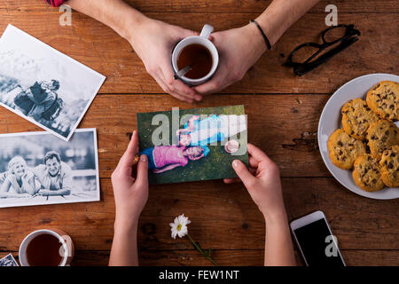 Mans und Womans Hände. Schwarz-weiß-Fotos. Paar. Tee, Kekse, Telefon. Stockfoto