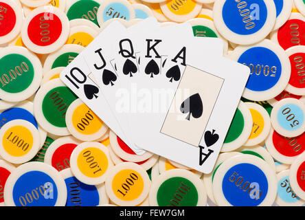 Poker-Blatt mit einem Straight Flush in Pik aufgefächert über einen bunten Hintergrund der Pokerchips Stockfoto