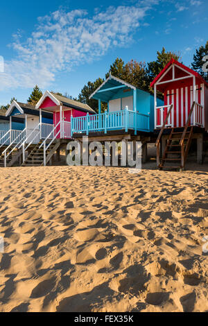 Bunte hölzerne Strandhütten auf sandigen Strand von Wells Next-the-Sea, Norfolk, Großbritannien Stockfoto
