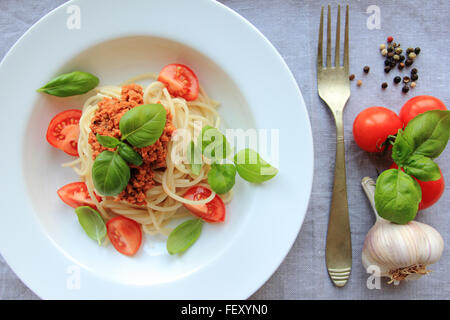 Spaghetti Nudeln mit Fleisch basierend auf Bolognese-Sauce mit frischem Basilikum auf weißen Teller Stockfoto