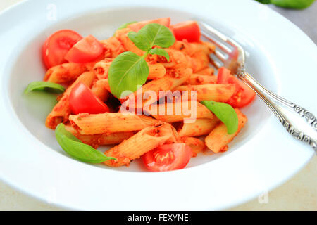 Penne-Nudeln in Tomatensauce auf weißen Teller Stockfoto