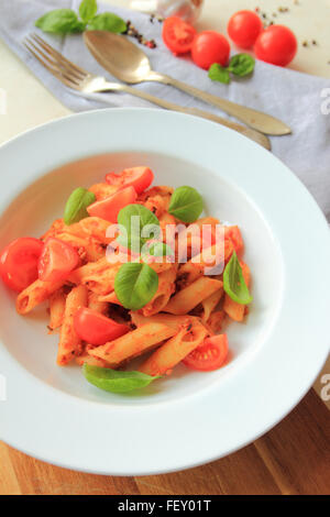 Penne-Nudeln mit Bolognese-Sauce mit frischem Basilikum auf weißen Teller Stockfoto