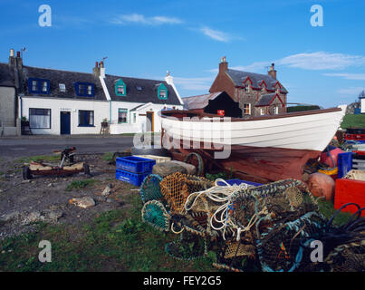 Traditionelle Hütten, Haus und und Fischerboot neben der Straße von der Fähre nach der Abtei in Baile Mor, Iona, Hebriden, Schottland, Vereinigtes Königreich Stockfoto