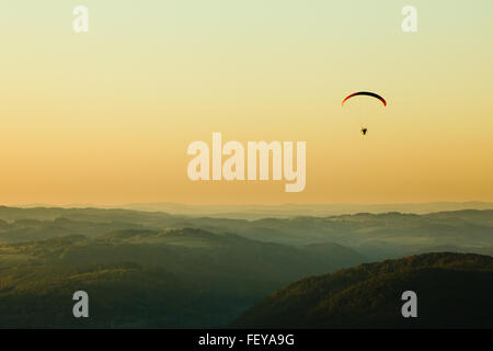 Moto-Gleitschirm über die Landschaft bei Sonnenuntergang, Textfreiraum Stockfoto