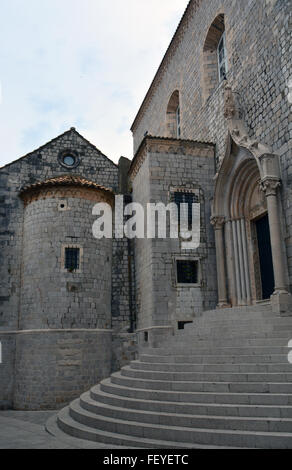 Über die geschwungene Treppe an der südlichen Tür des Dominikanerklosters in Dubrovnik steht eine Statue des St. Dominic. Stockfoto