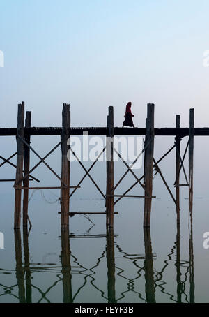 Buddhistischer Mönch überquert die U Bein Brücke - die längste Teakholz Fußgängerbrücke der Welt in Amarapura in der Nähe von Mandalay, Birma (Myanmar Stockfoto