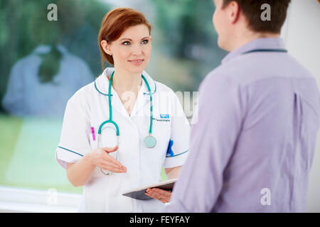 Arzt und Krankenschwester diskutieren Notizen Stockfoto