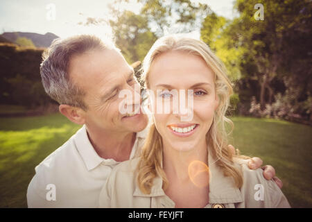 Mann etwas zu Wifes Ohren flüstern Stockfoto