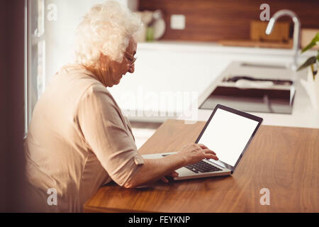Ältere Frau, die Eingabe auf laptop Stockfoto