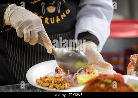 Hände der jungen Frau Koch eine Servierplatte Ceviche. Peruanische Würze und Geschmack, Essen Messe. La Limeñita Boulevard, Camana St Stockfoto