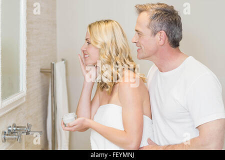 Frau auftragen Creme im Badezimmer Stockfoto