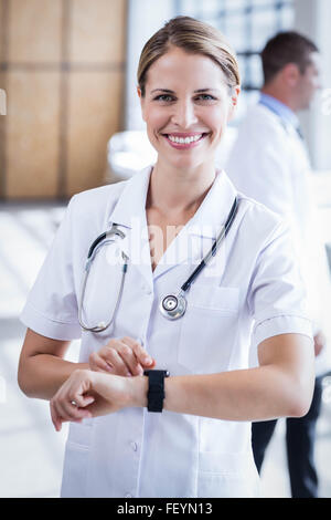 Überprüfung ihrer Smartwatch Krankenschwester Stockfoto