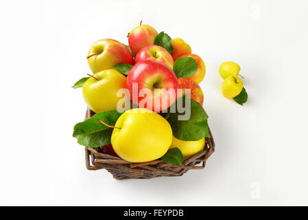 Nahaufnahme von roten und gelben Äpfeln im Weidenkorb Stockfoto