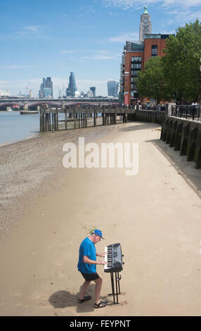 Straßenmusiker spielen Tastaturen am Strand des Flusses Themse auf der Southbank in London Stockfoto