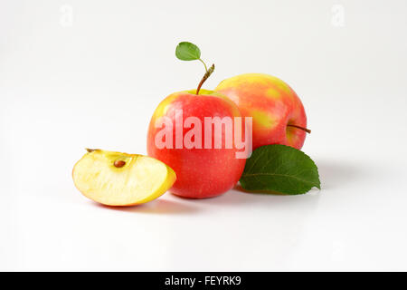 zwei und ein Viertel Äpfel auf weißem Hintergrund Stockfoto