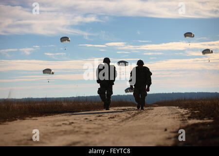 US-Fallschirmjäger zurück nach Abschluss ihre Sprünge in die Teilnahme für die 18. jährliche Randy Oler Memorial Betrieb Spielzeug fallen, moderiert von US Armee zivile Angelegenheiten & psychologische Operations Command (Airborne), 4. Dezember 2015, in Fort Bragg, N.C. Betrieb Spielzeug Tropfen ist eines der weltweit größten kombinierten Luftlandeoperationen und Soldaten die Möglichkeit zu helfen, Kinder in Not Spielzeug für den Urlaub erhalten. Stockfoto