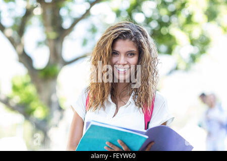 Hip Frau Notebook hält lächelnd in die Kamera Stockfoto