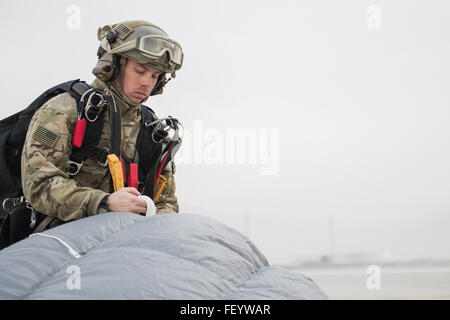 Senior Airman Josiah Stromstad, 83. Expeditionary Rescue Squadron Pararescueman packt seinen Fallschirm nach dem Sprung aus einem HH-60 Pave Hawk in Bagram Air Field, Afghanistan, 22. November 2015. Das Team springt an Leistungsfähigkeit zu erhalten und für ihre Mission zur Unterstützung der Operation Freedom Sentinel zu trainieren. (Techn. Sgt. Robert Cloys/freigegeben) Stockfoto