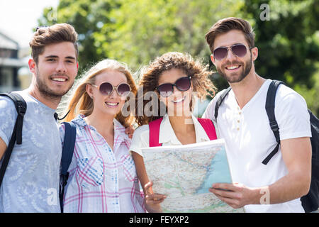 Hip Freunde im Besitz Karte und schaut in die Kamera Stockfoto