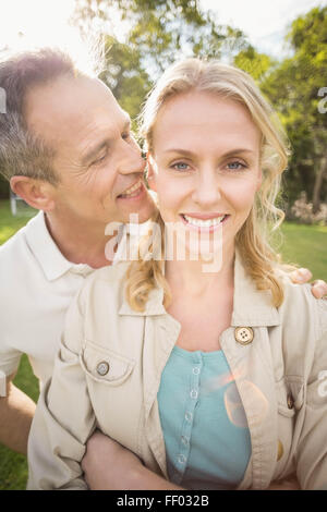 Mann etwas zu Wifes Ohren flüstern Stockfoto