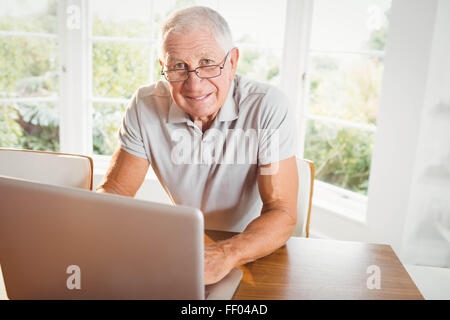Lächelnder senior Mann mit laptop Stockfoto