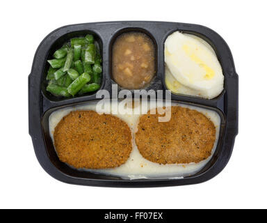 Draufsicht eines gefrorenen Brathähnchen Bratlinge TV Dinner mit Kartoffeln, grüne Bohnen und Äpfel in der Soße auf einem weißen Hintergrund. Stockfoto