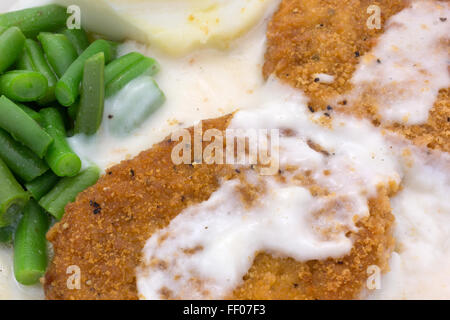 Nahaufnahme einer Mikrowelle Brathähnchen Bratlinge Soße TV Dinner mit Kartoffelpüree und grünen Bohnen. Stockfoto