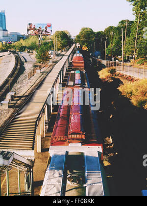 Ein Stadtzug fährt entlang seiner Strecke, ein wichtiger Bestandteil des öffentlichen Nahverkehrs in der Stadt. Die Bewegung des Zuges und die umliegende städtische Landschaft heben die modernen Verkehrssysteme hervor. Stockfoto