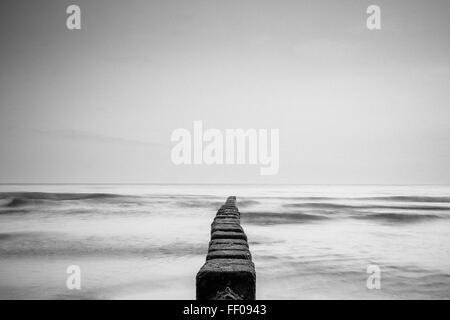 Eine minimalistische monochrome Darstellung des Ozeans mit Schwarz-weiß-Kontrasten mit hellen Wellen und einer ruhigen Wasseroberfläche. Das Bild unterstreicht die Einfachheit und Gelassenheit der Meereslandschaft. Stockfoto