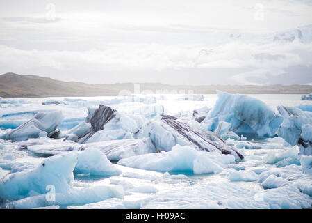 Eine Szene von Eisbergen, die in den arktischen Gewässern herumschwirren. Die gefrorenen Eisbrocken schwimmen auf dem kalten Ozean und symbolisieren die Weite der Polarregion und die Umweltbedeutung dieser Eisformationen. Stockfoto