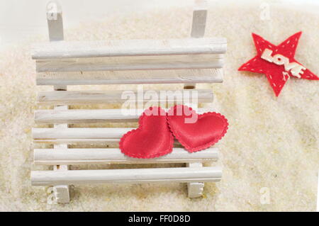 Zwei Herzen auf einer Miniatur-Holzbank mit Liebe note Stockfoto