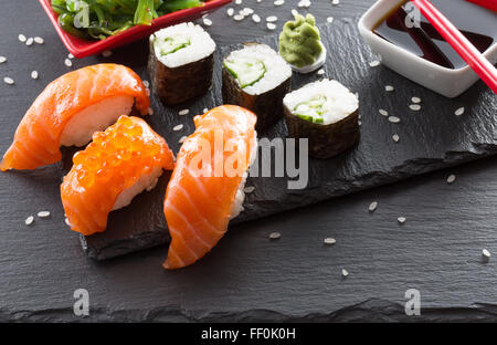 Sushi und Rollen auf Schiefer Tisch. Stockfoto