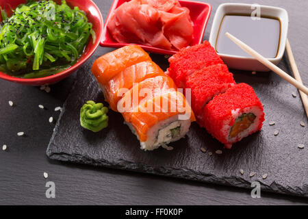 mit Seasalad, Sojasauce und rosa Ingwer Scheiben rollt auf einem Schiefer Tisch. Stockfoto