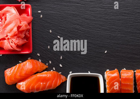 Sushi-Rollen mit Ingwer und Sauce auf einem Schiefer Tisch. Stockfoto