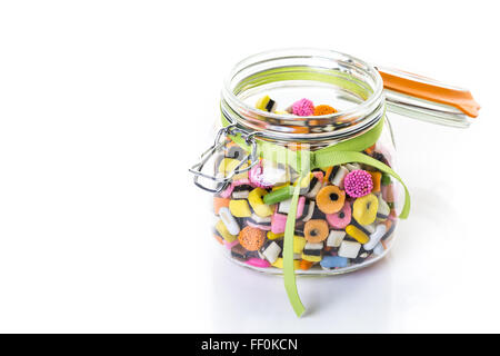 Bunte Bonbons im Glas Candy jar auf weißem Hintergrund. Stockfoto