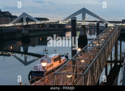 Tradeston Crossing und Liegeplätze bei niedrigem Wasserstand markieren, River Clyde, Glasgow in der Abenddämmerung. Stockfoto