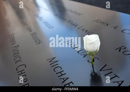 Eine weiße rose schmückt ein Denkmal mit den Namen der Opfer der Anschläge in New York City World Trade Center 911. Stockfoto
