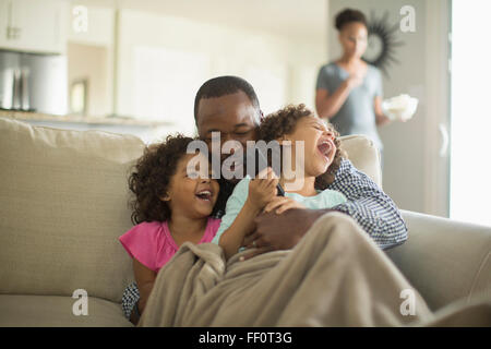 Vater und Töchter spielen auf sofa Stockfoto