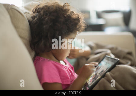 Mädchen mit digital-Tablette auf sofa Stockfoto