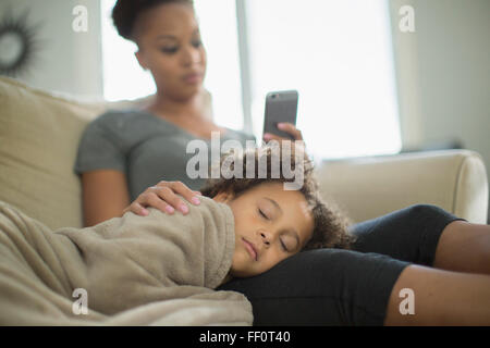 Mutter und Tochter auf Sofa kuscheln Stockfoto