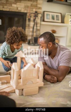 Vater und Tochter spielen mit Bausteinen im Wohnzimmer Stockfoto