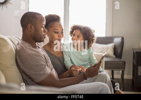 Familie mit digital-Tablette auf sofa Stockfoto