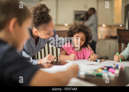 Mutter und Kinder, die Zeichnung in der Küche Stockfoto