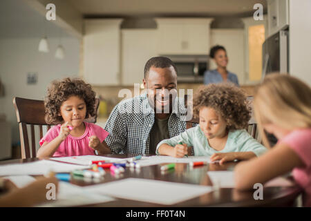 Vater und Kinder, die Zeichnung in der Küche Stockfoto