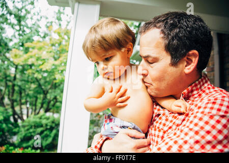 Vater Holding Sohn auf Veranda Stockfoto